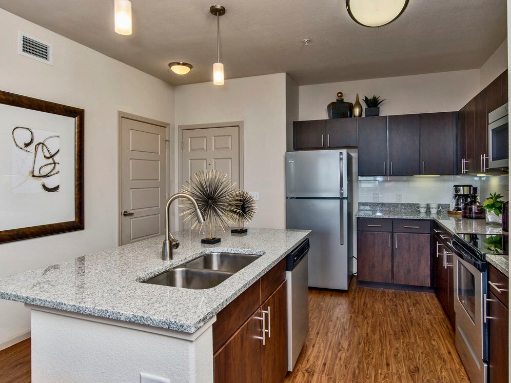 Classic Package I kitchen with espresso cabinetry, speckled granite countertops, white subway tile backsplash, stainless steel appliances, and hard surface flooring