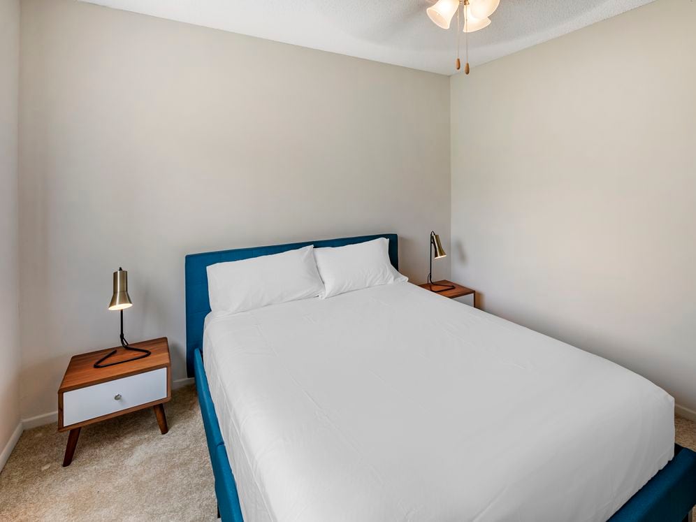 Furnished+ apartment homes feature queen bed with mattress, two pillows, dresser, nightstands, lamp, and mirror. (Representative Image – exact items and style of furnishings may vary)