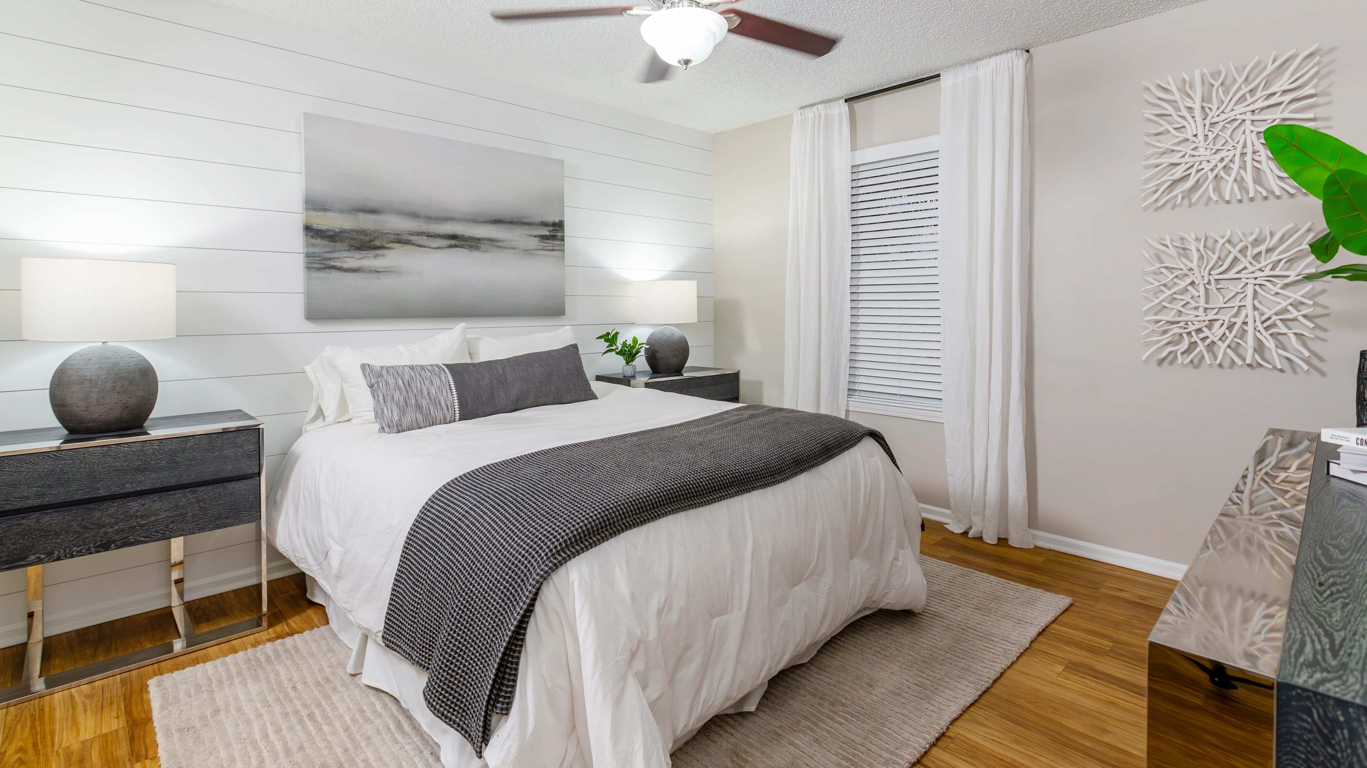 Spacious master bedroom featuring wood-style flooring, multi-speed ceiling fan, and a master bath.