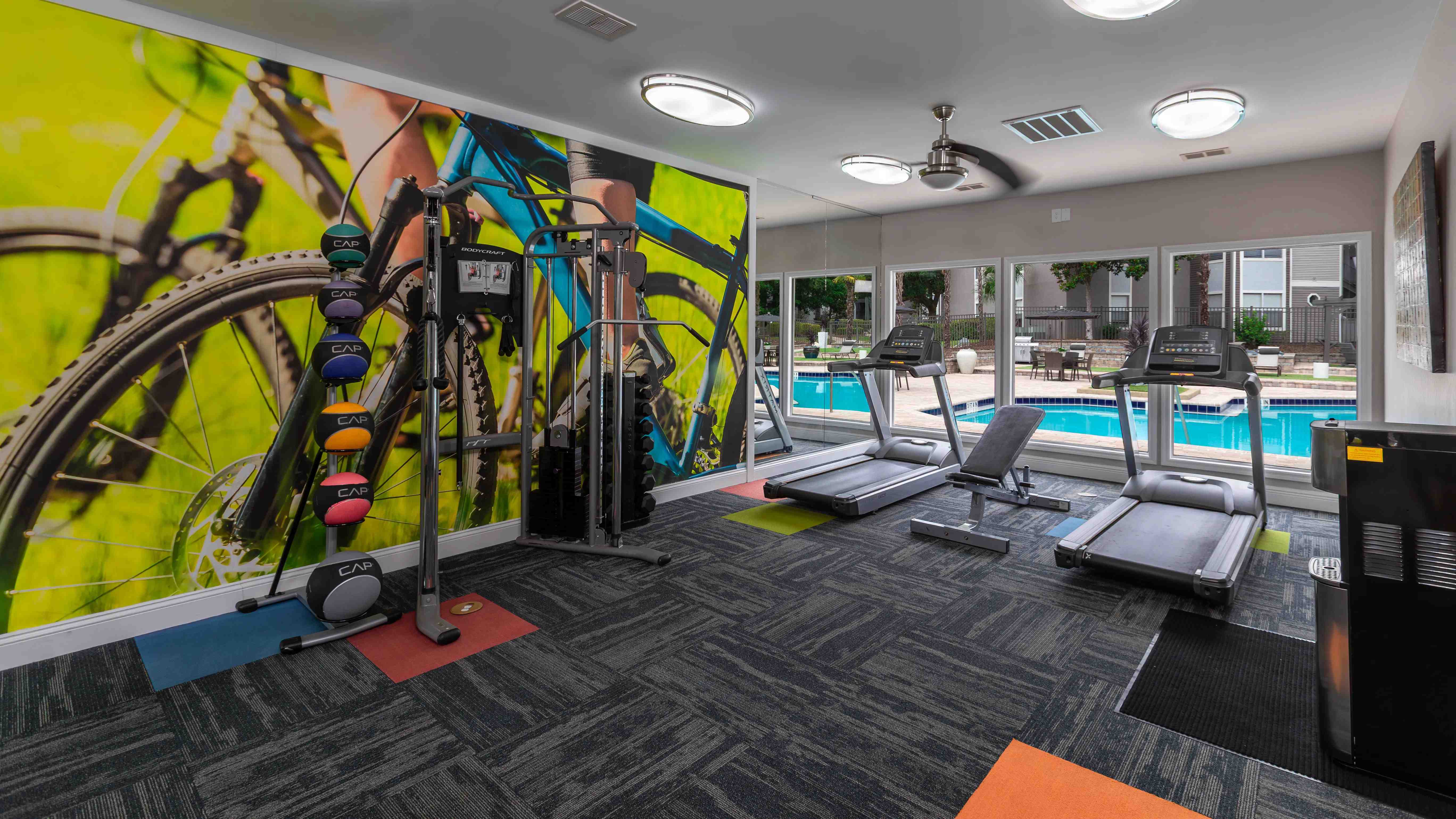 Our fully equipped fitness center features treadmills, free weights, and sunny views of the resort-style pool.