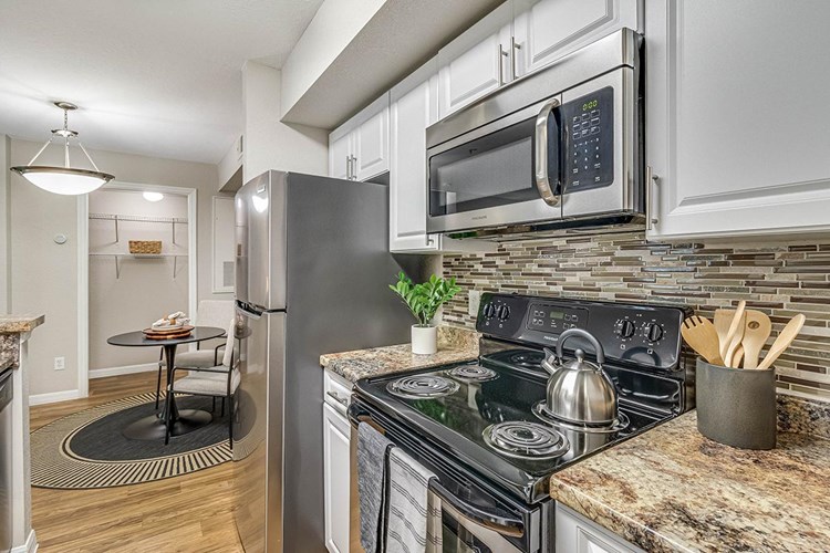 Kitchens feature stainless steel appliances and a backsplash.