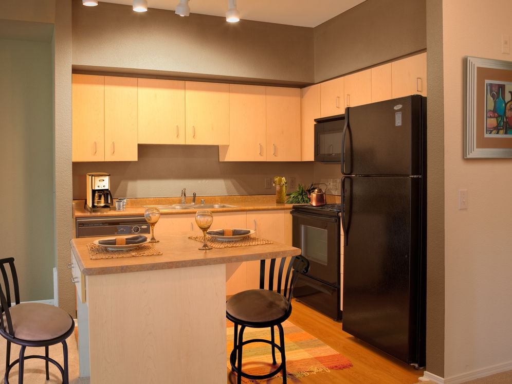 Classic Package I kitchen with black appliances, laminate countertops, oak cabinetry, and hard surface flooring