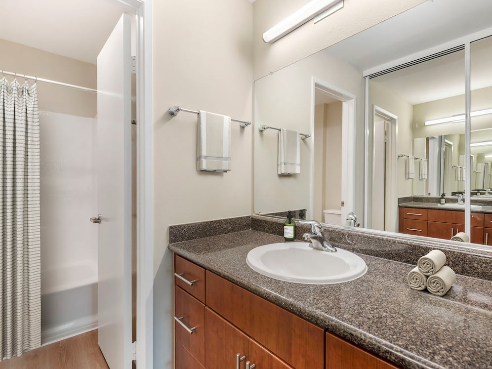 Classic Package II bath with grey speckled granite countertops, chestnut cabinetry, and hard surface flooring