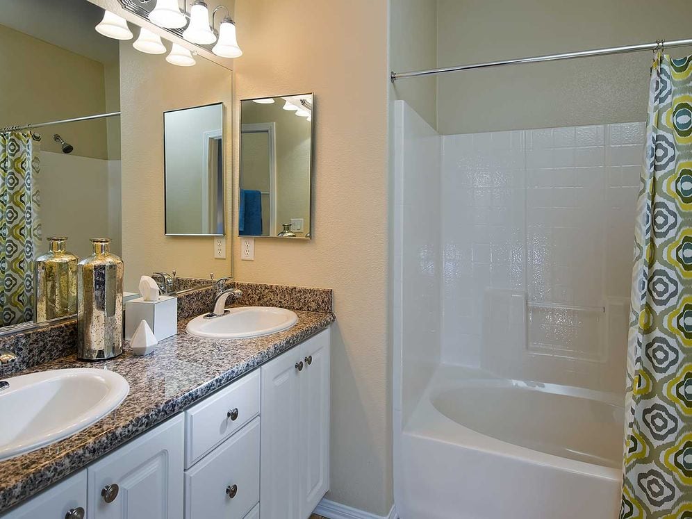 Classic Package I bath with beige speckled granite countertop, white cabinetry, and hard surface flooring