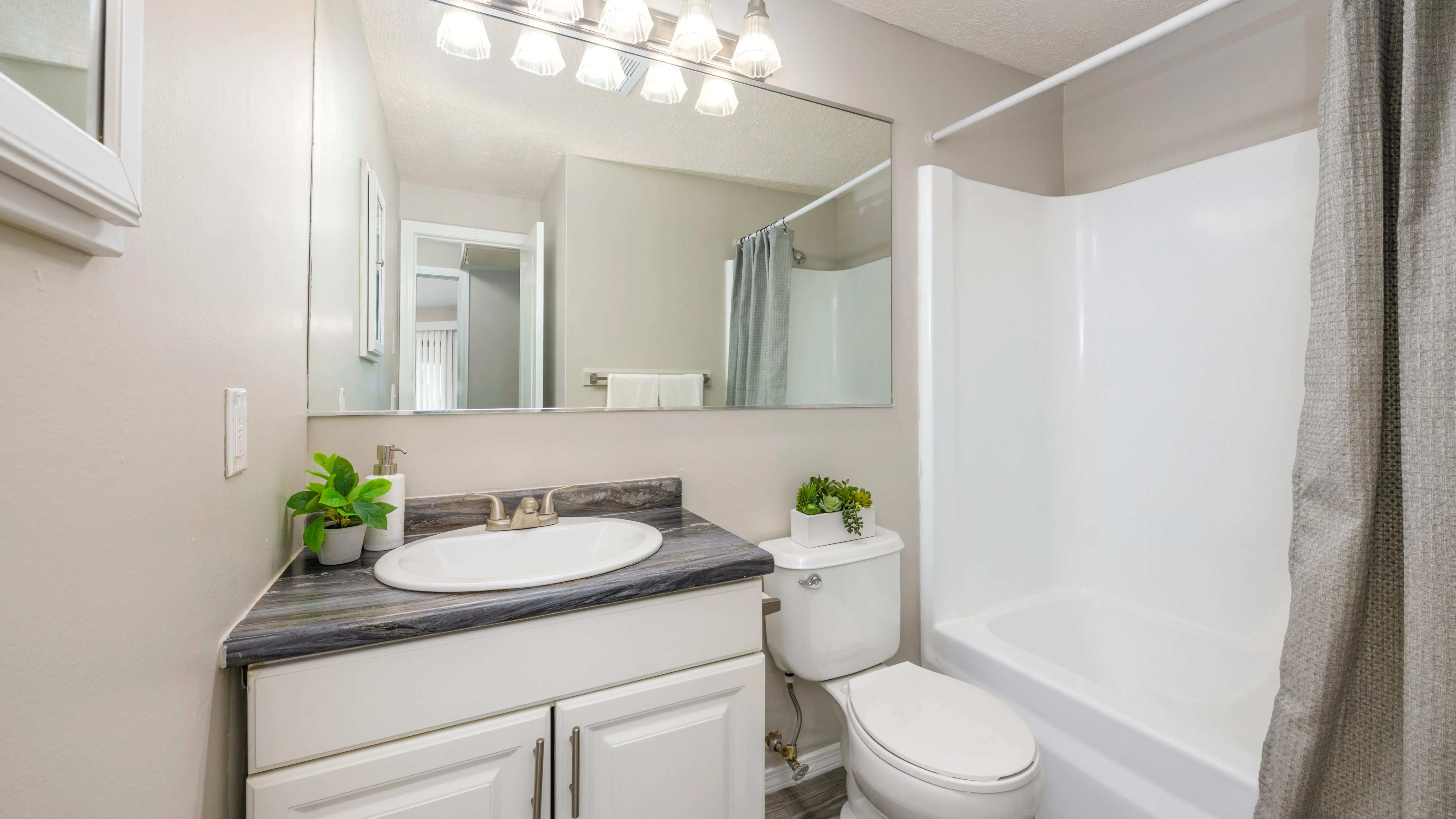 Elevate your daily routine in your bathroom retreat, featuring an oversized mirror that adds space, light, and a touch of luxury to your every day.