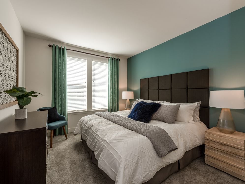 Bedroom with accent wall and carpeted flooring
