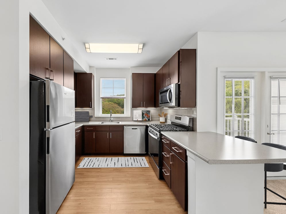 Updated Finishes kitchen with stainless steel appliances, espresso cabinetry, tile backsplash, laminate countertops, and hard surface flooring