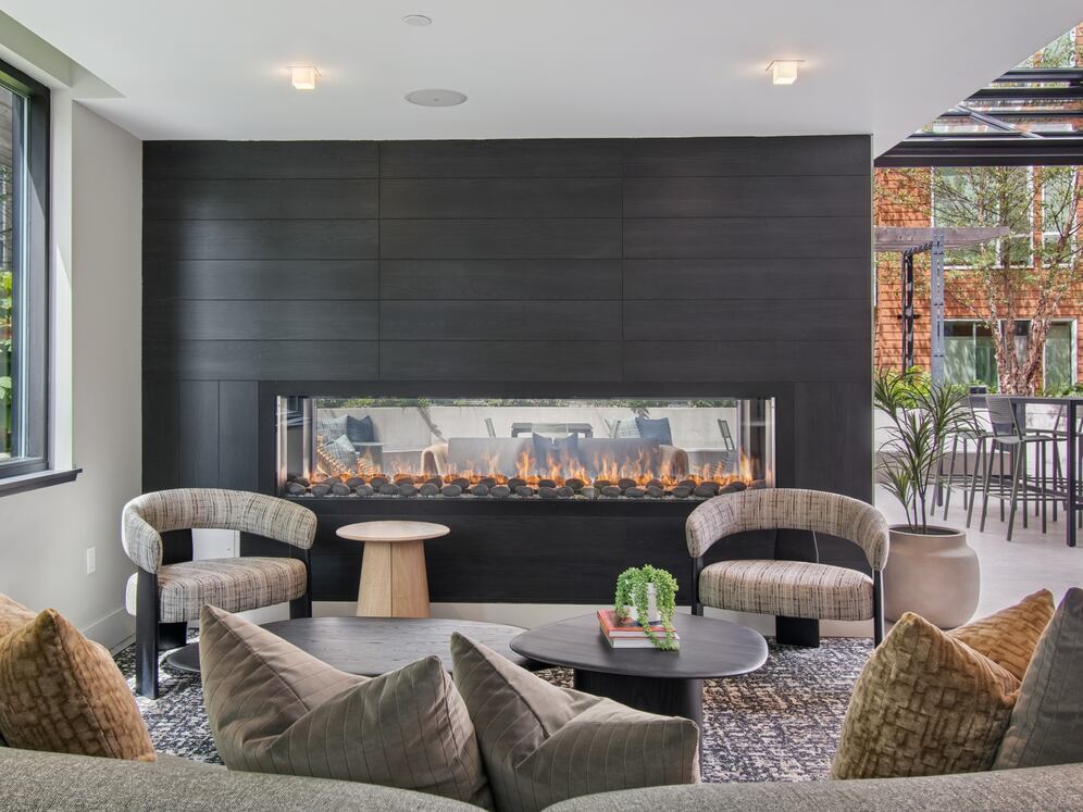 Resident lounge with common area seating, fireplace, and patio