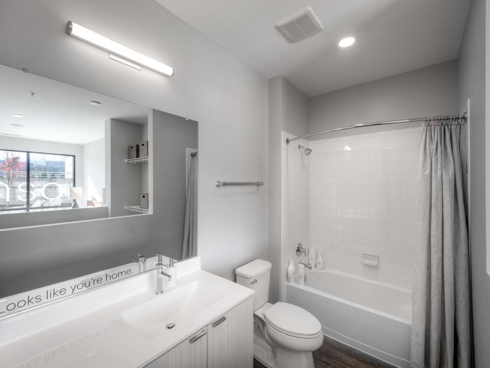 Showroom bath with white cabinetry, quartz stone countertop, and hard surface flooring