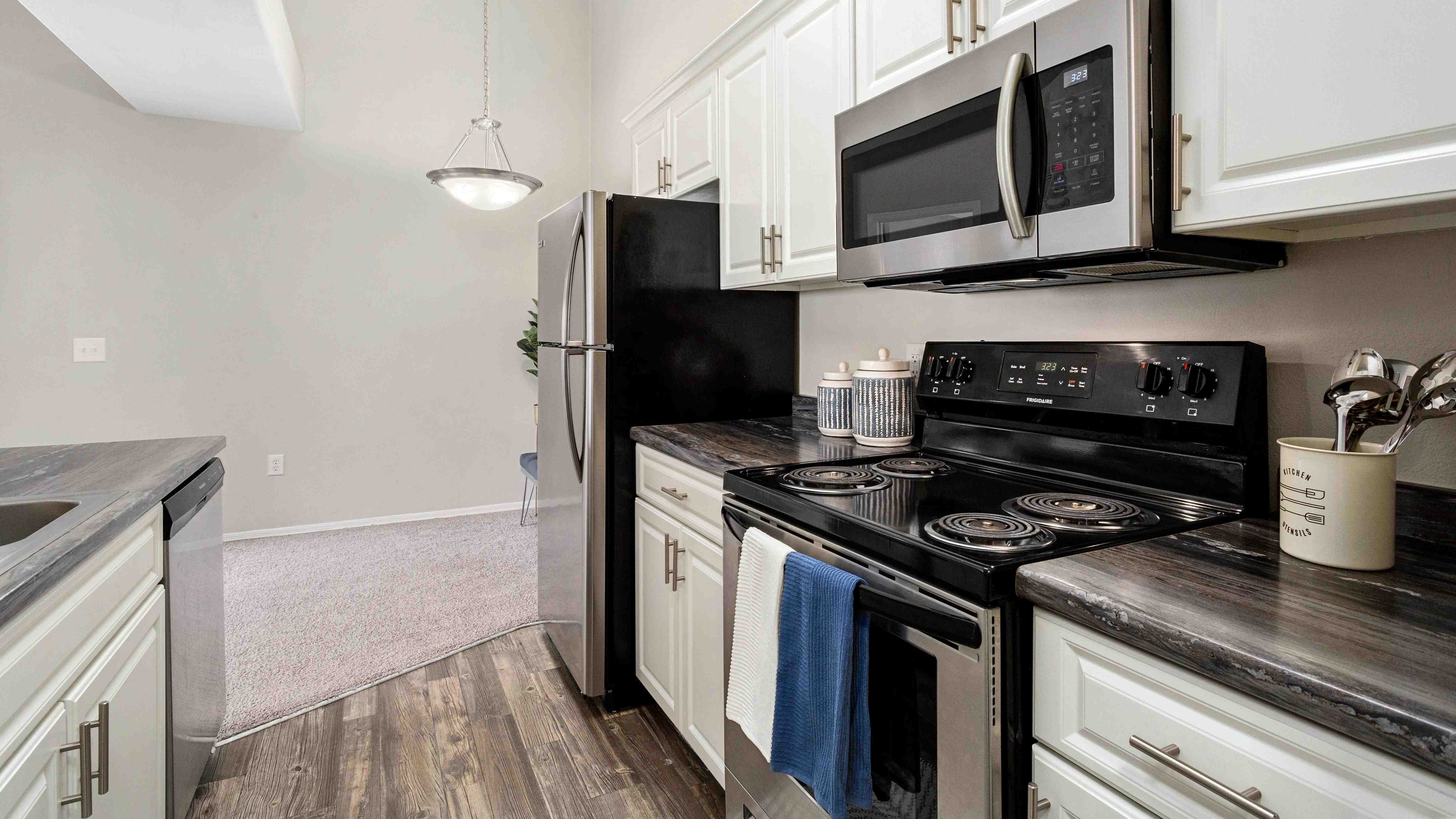 Our premium style floor plans feature kitchens with stainless steel appliances, white cabinetry and wood-style flooring.