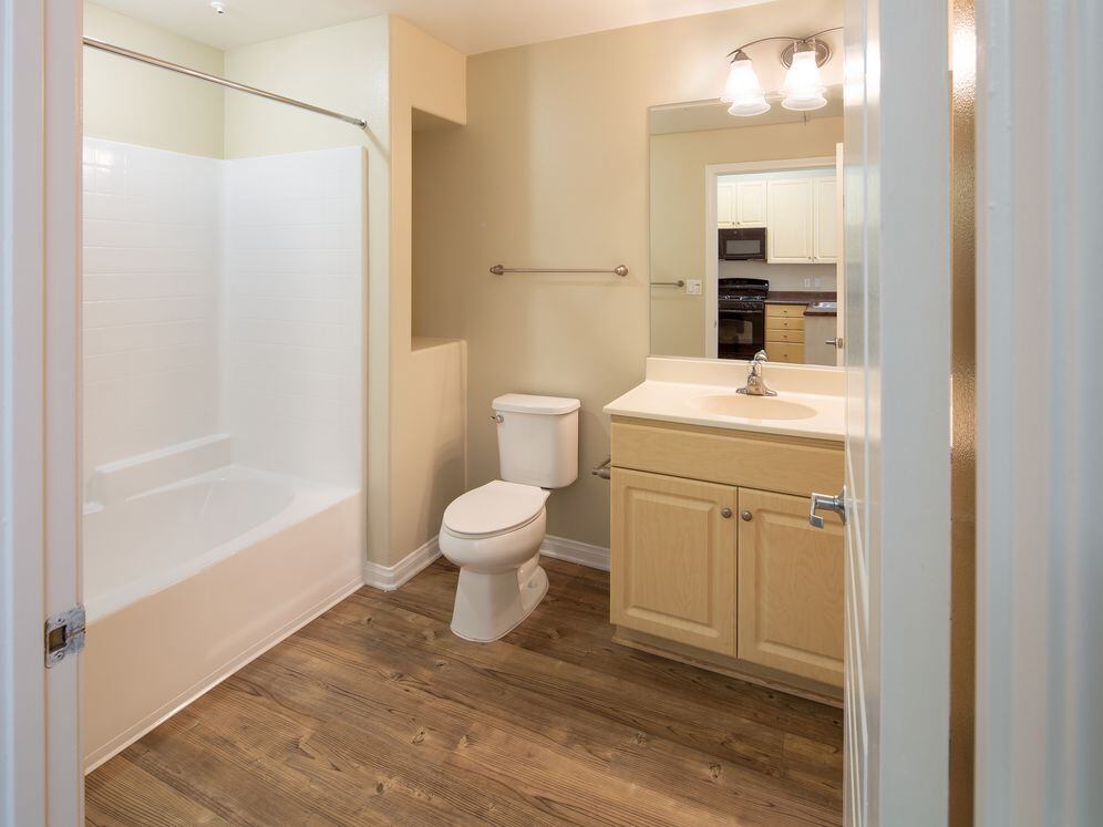 Bath with oak cabinetry, white countertop, and hard surface flooring