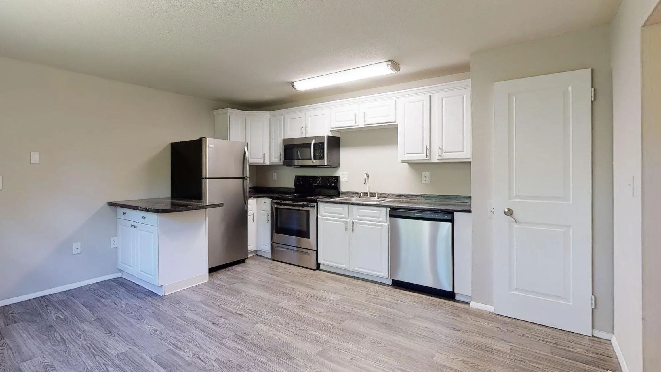 With an open layout, this kitchen includes updated appliances, a large countertop extension, and luxury vinyl flooring.