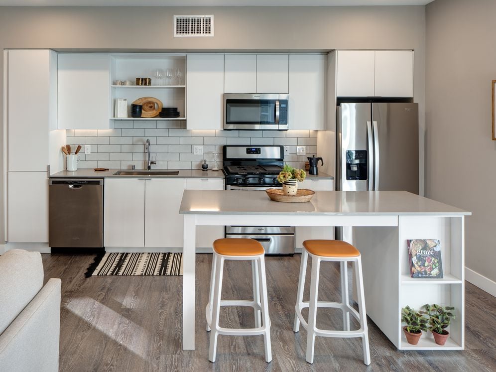 Open concept kitchen with quartz countertops, island, tile backsplash, and stainless steel appliances