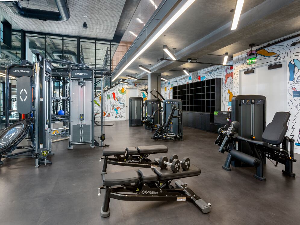 Fully-loaded fitness center with mural art by Priscilla Witte