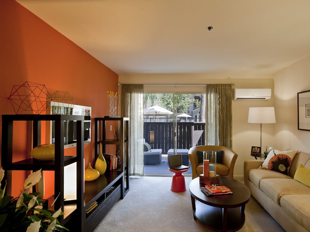 Classic Package living area with carpeted flooring, accent wall and patio access