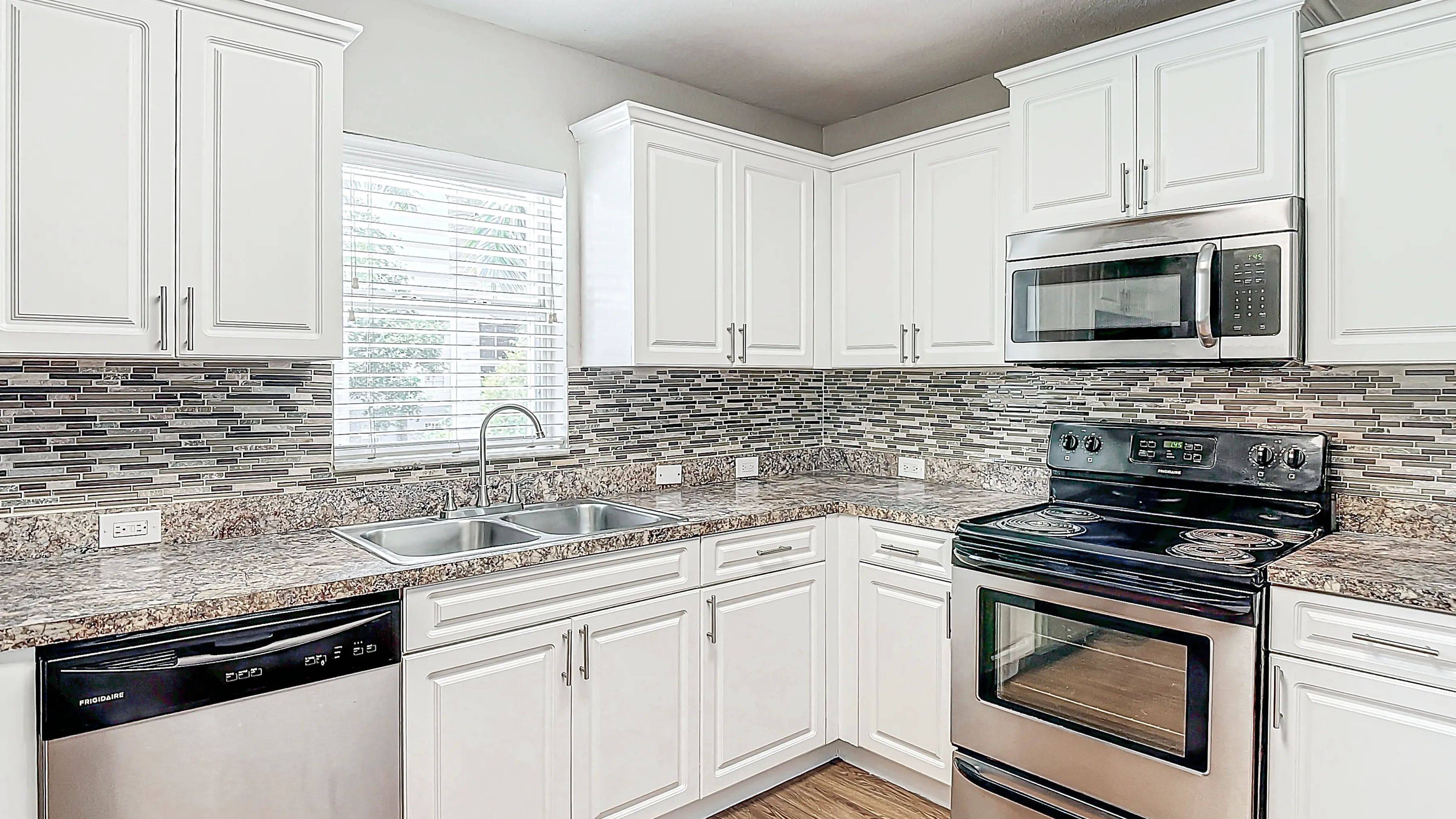 The Suite kitchen features a chic mosaic tile backsplash, offering a modern and sleek look.