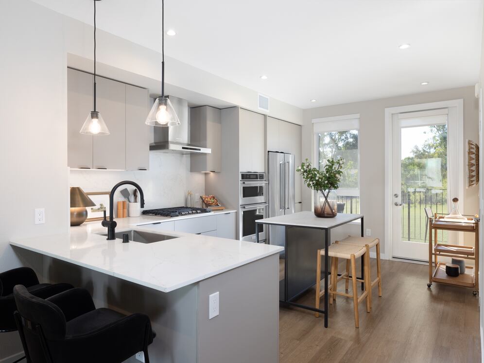 Signature Collection I 3-Bedroom Townhome Kitchen with upgraded stainless steel appliances, pendant lighting, and undercabinet lighting