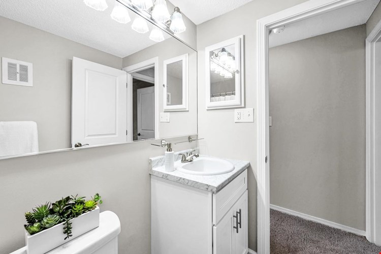 Newly remodeled bathrooms featuring wood-style flooring and marble-style counter tops.