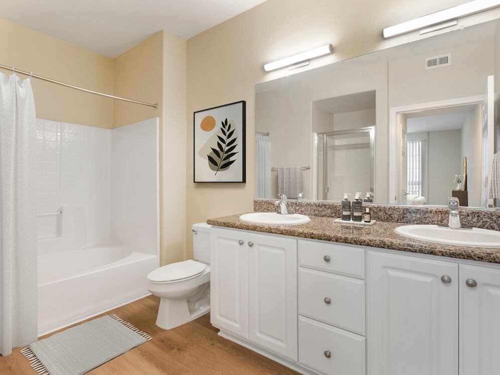 Renovated Package I bath with beige speckled granite countertop, white cabinetry, and hard surface flooring