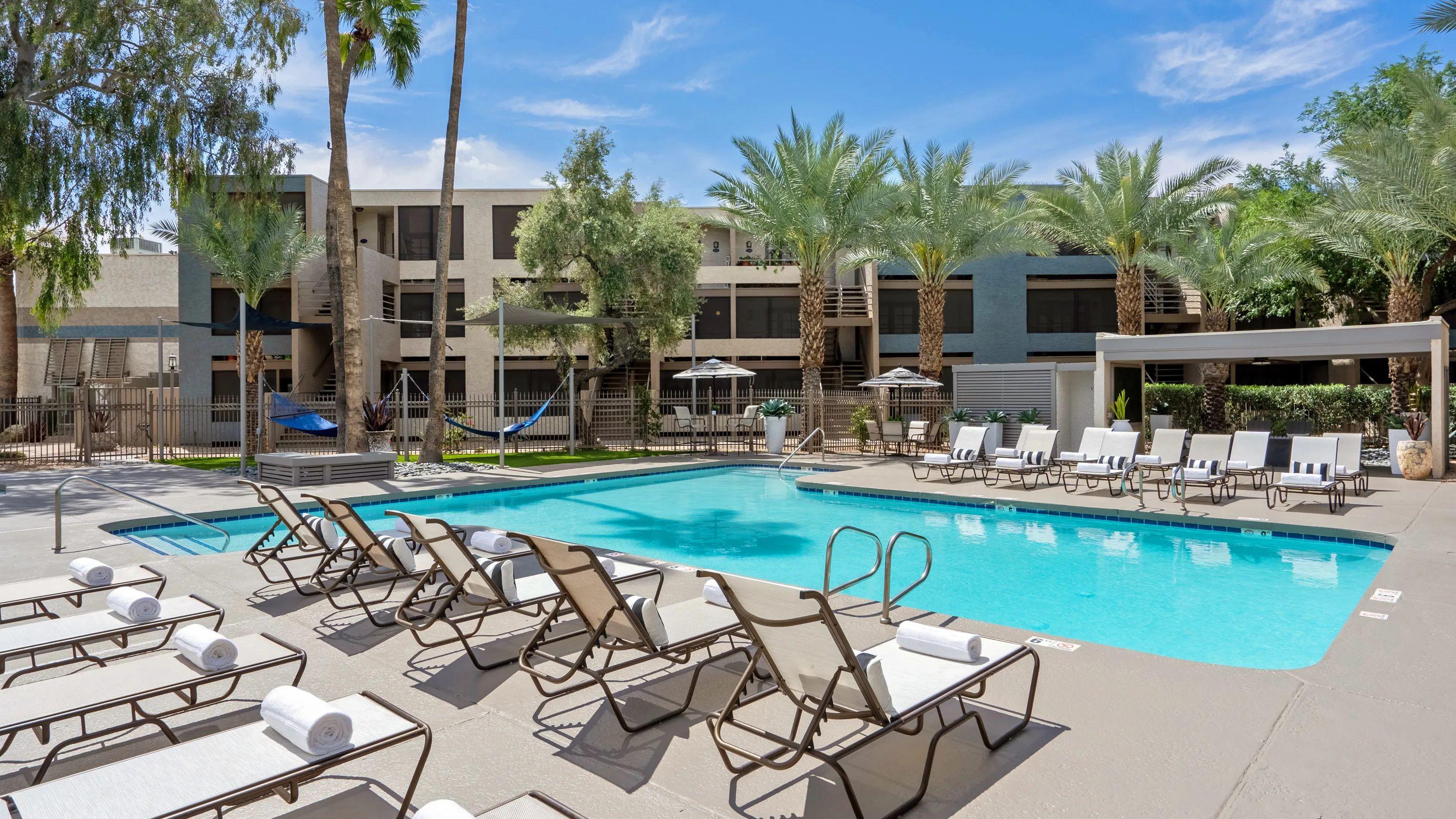 Enjoy the sun-drenched pleasures of resort-style living at home, with rows of inviting sun loungers and other relaxing options around the expansive pooldeck. 