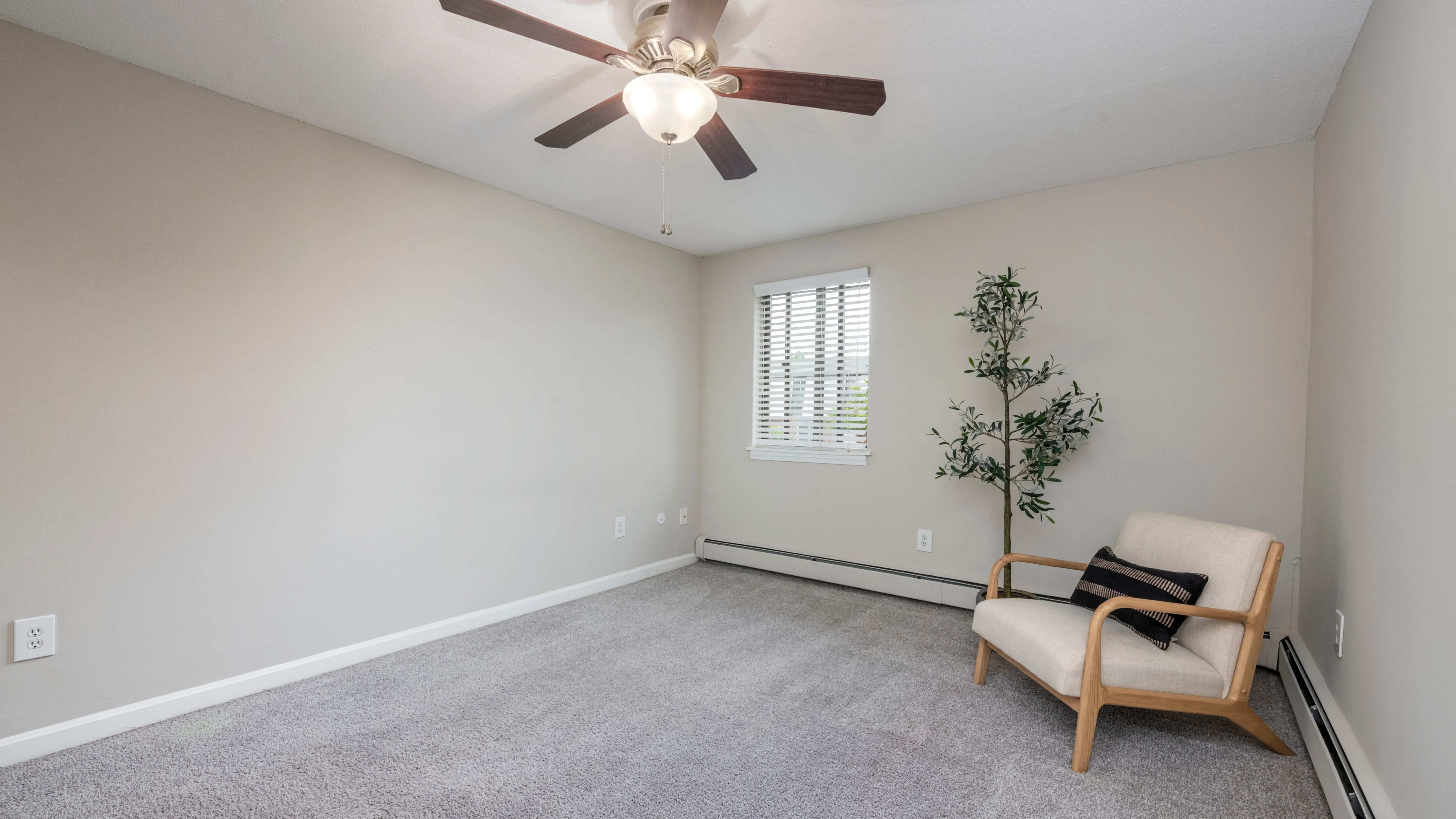 Discover plush bedroom bliss with large windows, plush carpeting, and a ceiling fan for your restful nights.