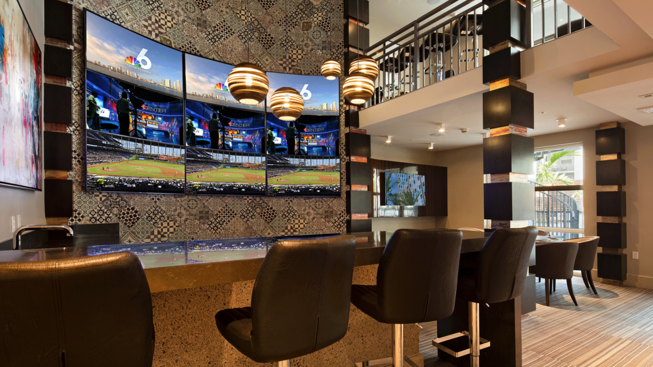 Hip sports lounge with flat screen TVs and bar-style seating.