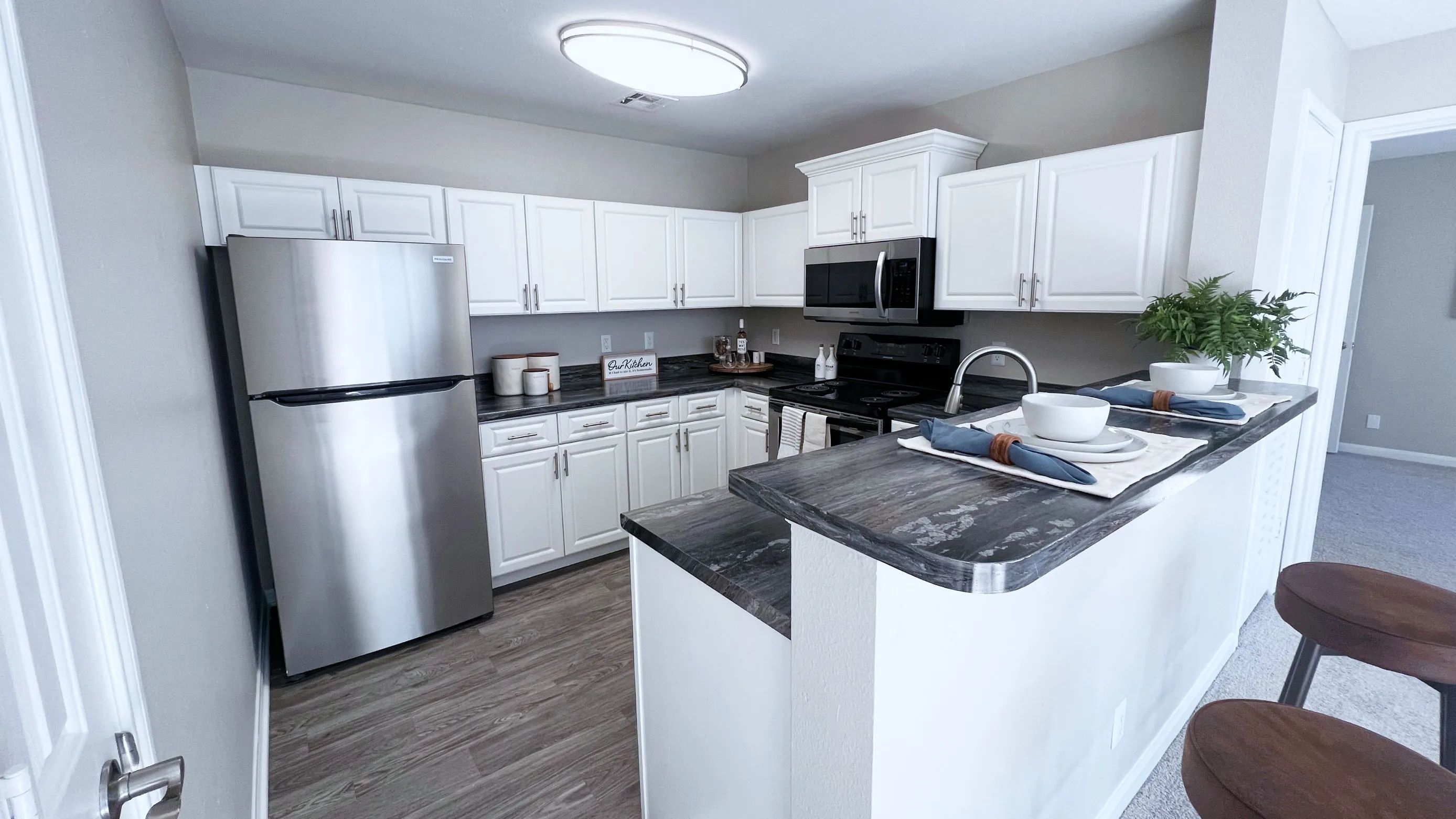 Upgrade your cooking space with chic white cabinetry and black fusion countertops.