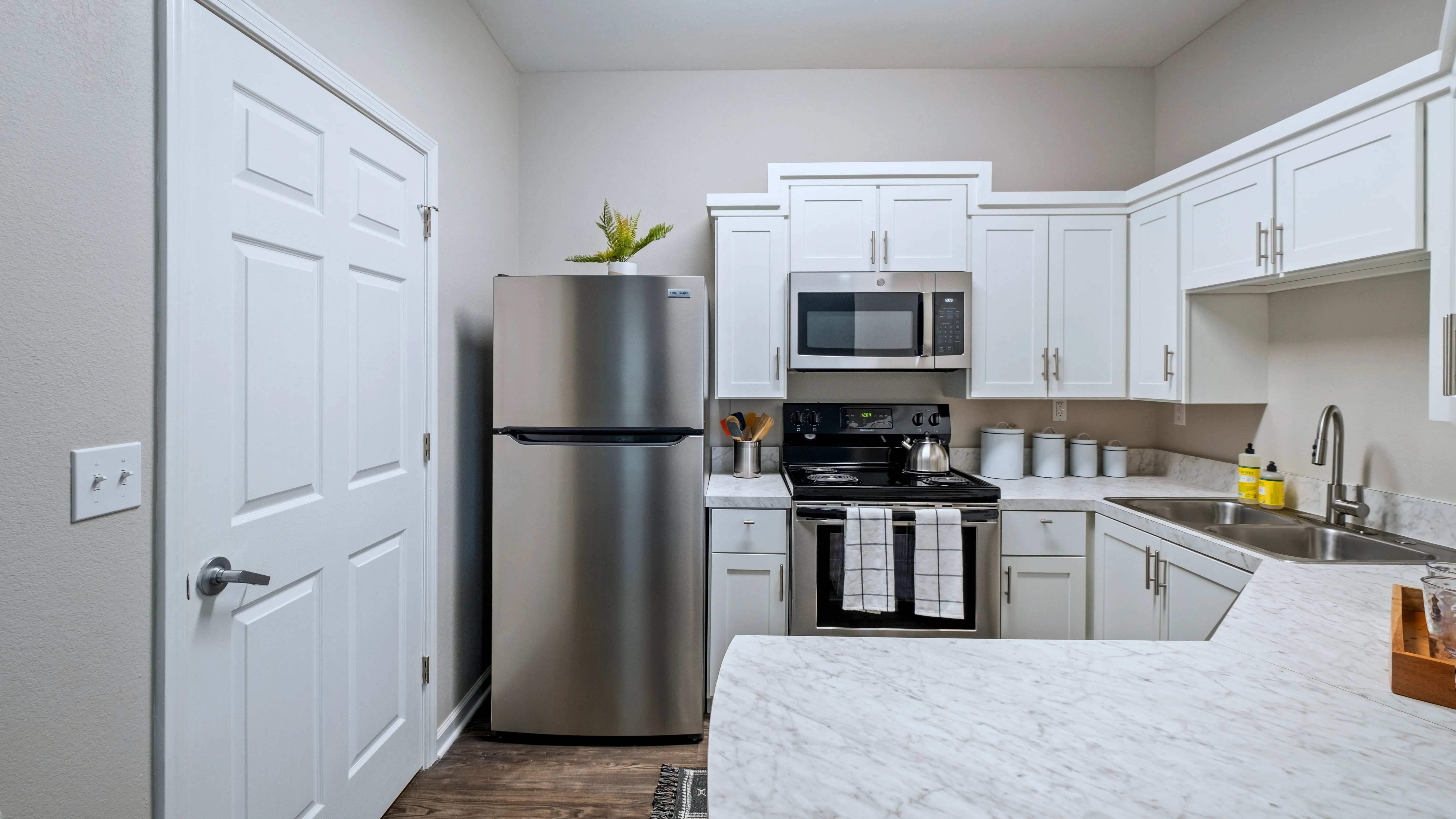 Fall in love with the newly remodeled kitchen, where stunning white marble-inspired countertops create a magical ambiance for your culinary adventures and a breakfast bar that opens to the living space for full enjoyment.  