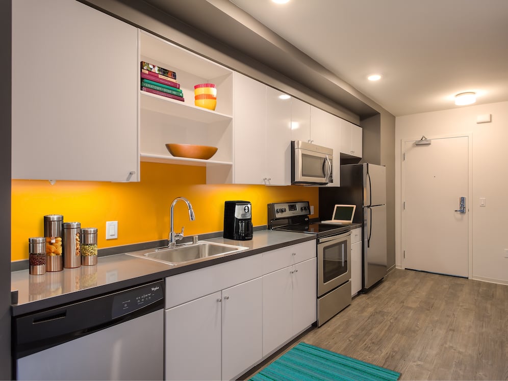 Open concept kitchen with white cabinetry, stainless steel appliances, chrome countertops and hard surface flooring