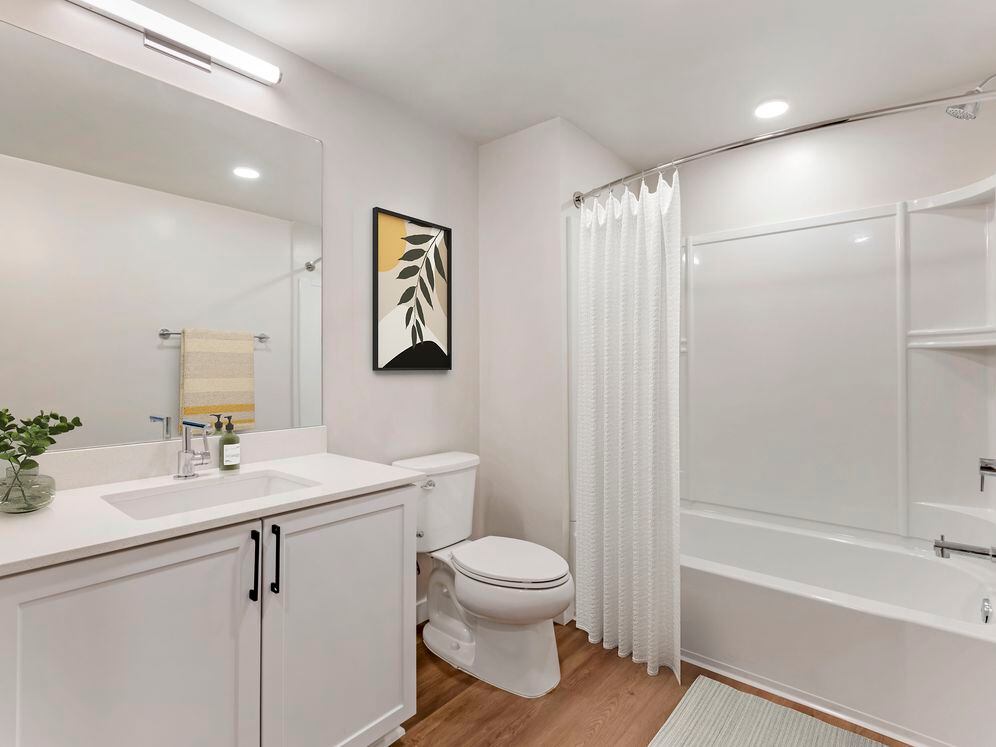Renovated Package II bath with white quartz countertops, white cabinetry, and hard surface flooring