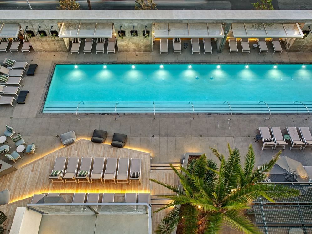 Pool and sundeck with cabanas and lounge seating