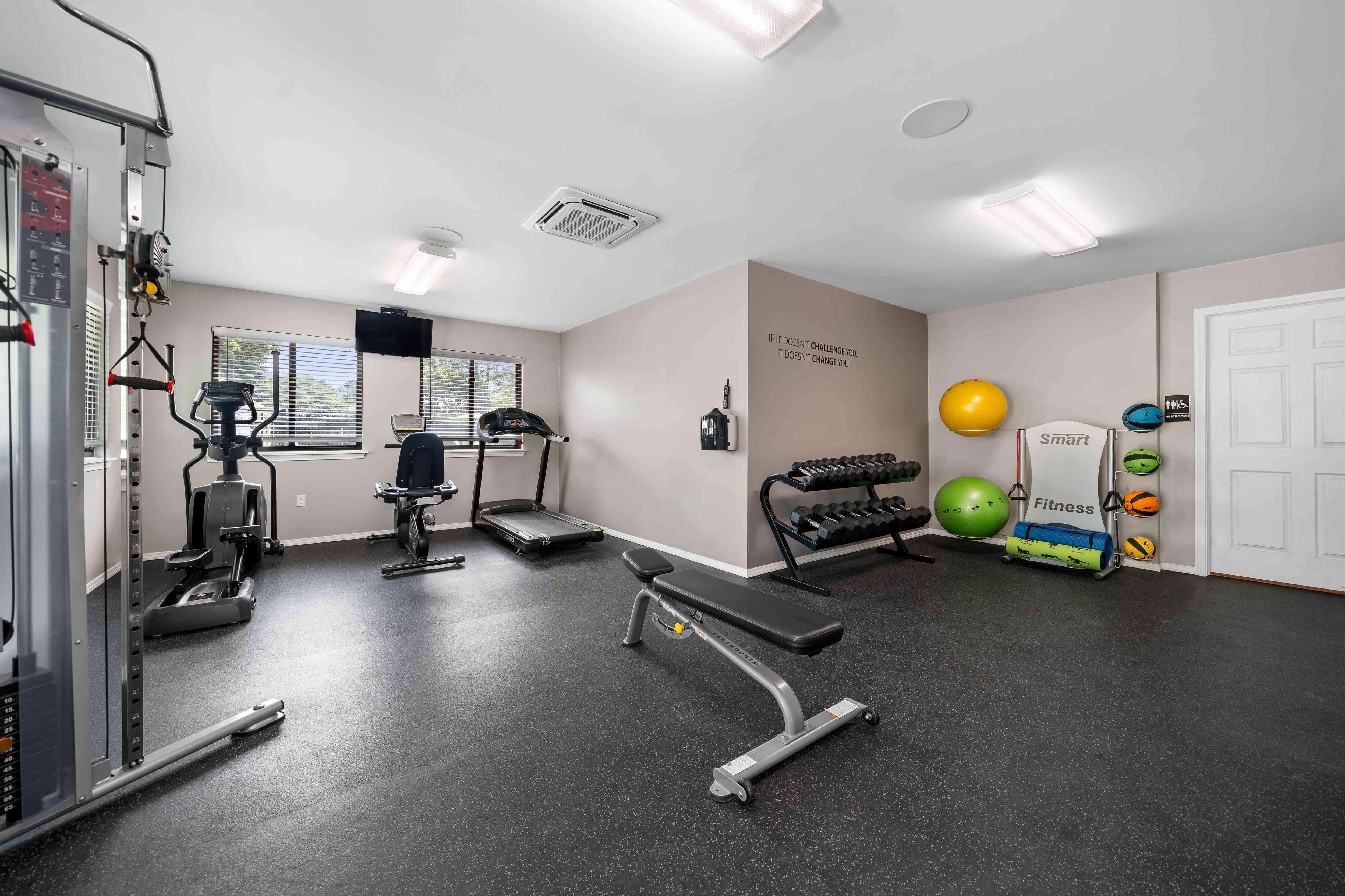 24-hour fitness center at cardio machines and weights at Woodland Villa Apartments in Westland, MI.
