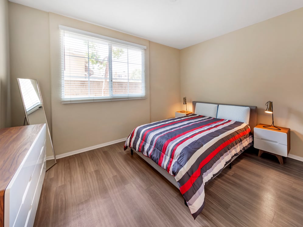 Furnished+ apartment homes feature queen bed with mattress, two pillows, dresser, nightstands, lamp, and mirror. (Representative Image – exact items and style of furnishings may vary)