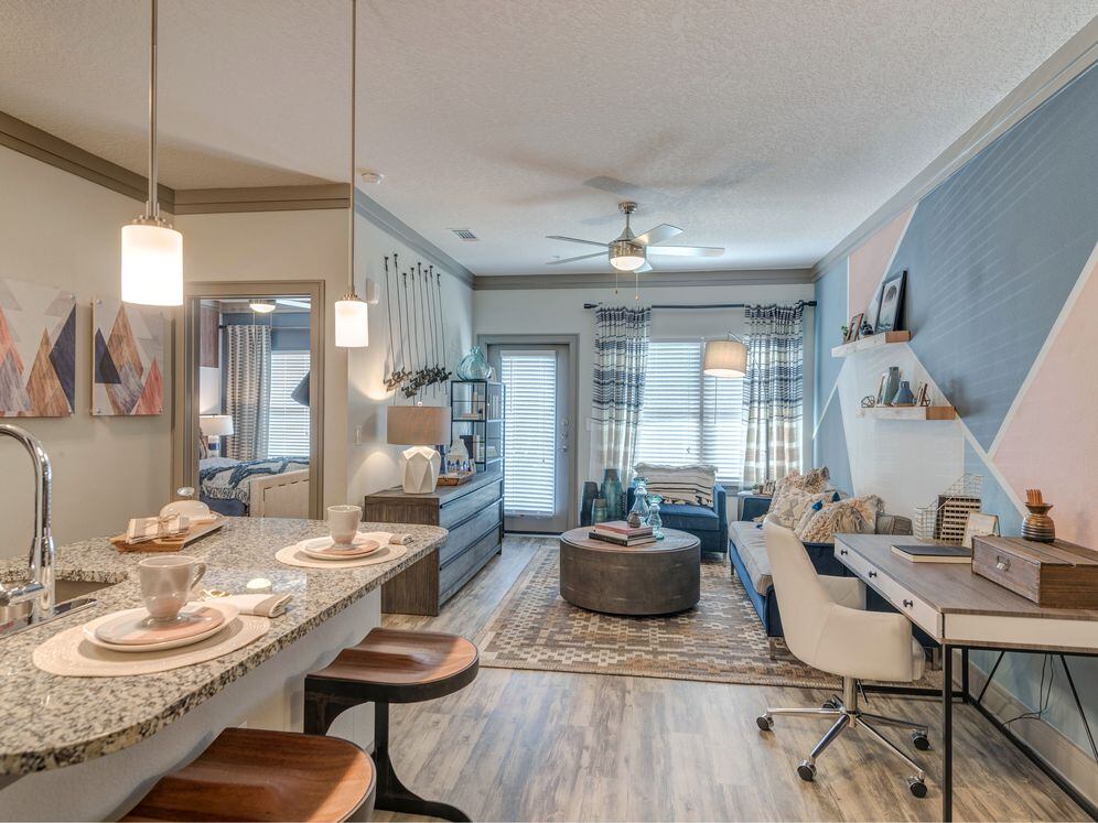Kitchen with pendant lighting and living area with hard-surface flooring
