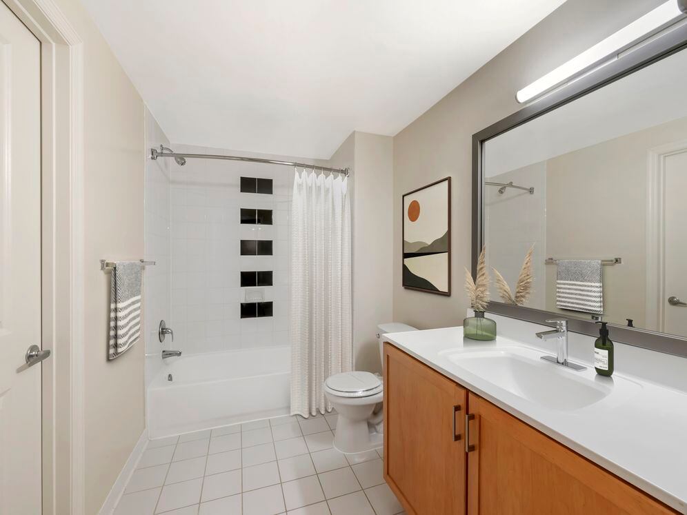 Updated Finishes bath with white laminate countertops, oak cabinetry, and hard surface flooring