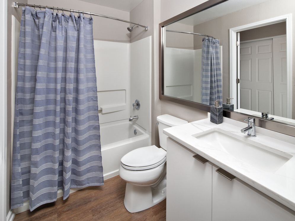 Premier Scheme bath with white flat cabinetry, white marbled quartz countertops, and hard surface flooring
