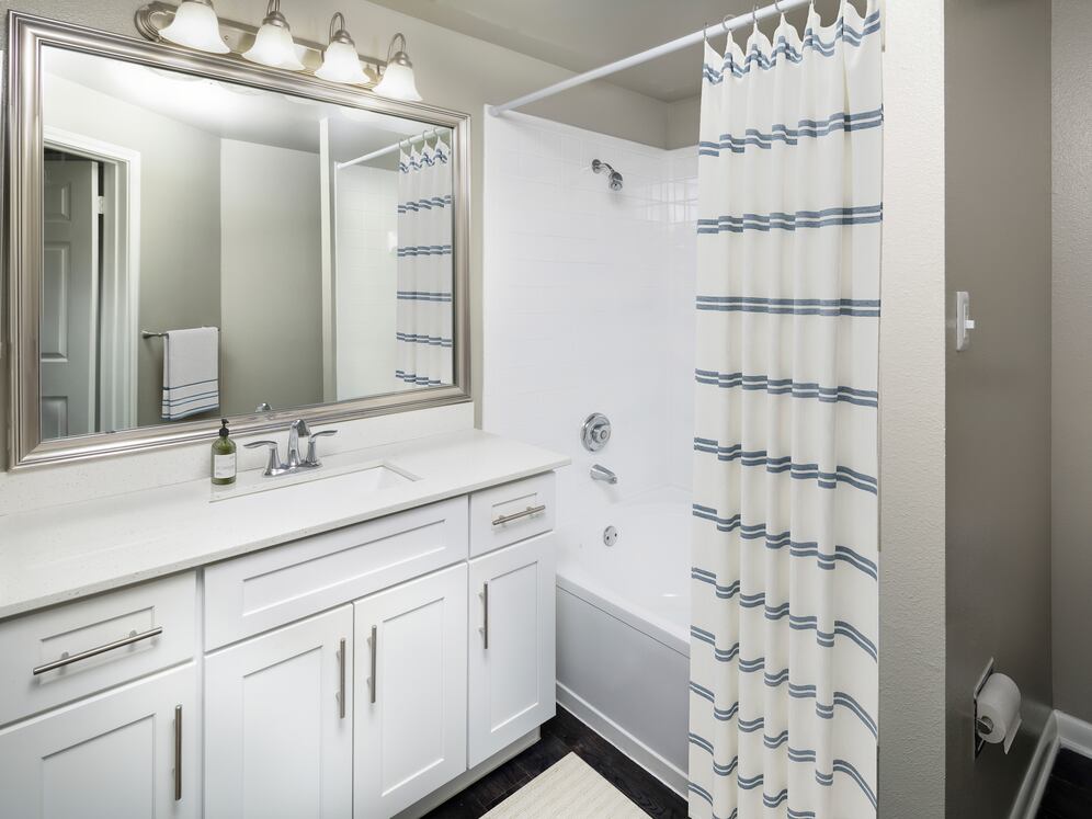 Classic Package II bath with white quartz countertop, white cabinetry, and hard-surface flooring