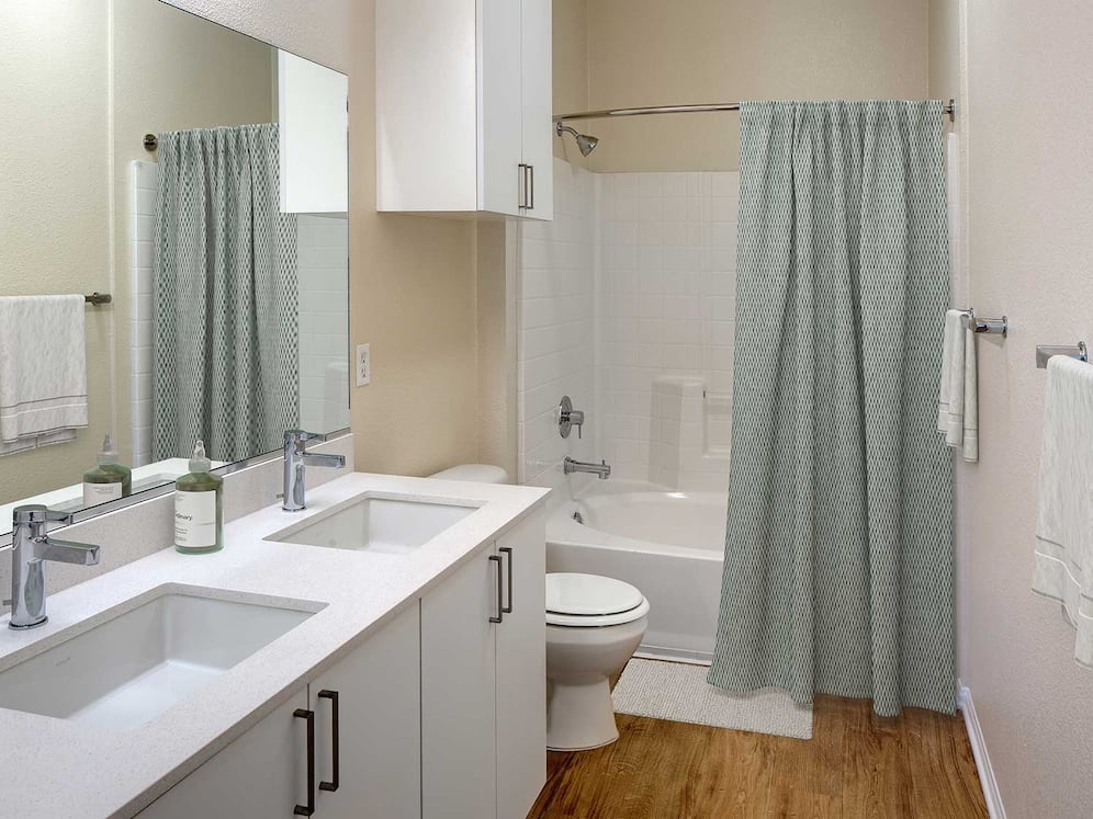 Renovated Package I bathroom featuring white cabinetry, white quartz countertops, and hard surface flooring