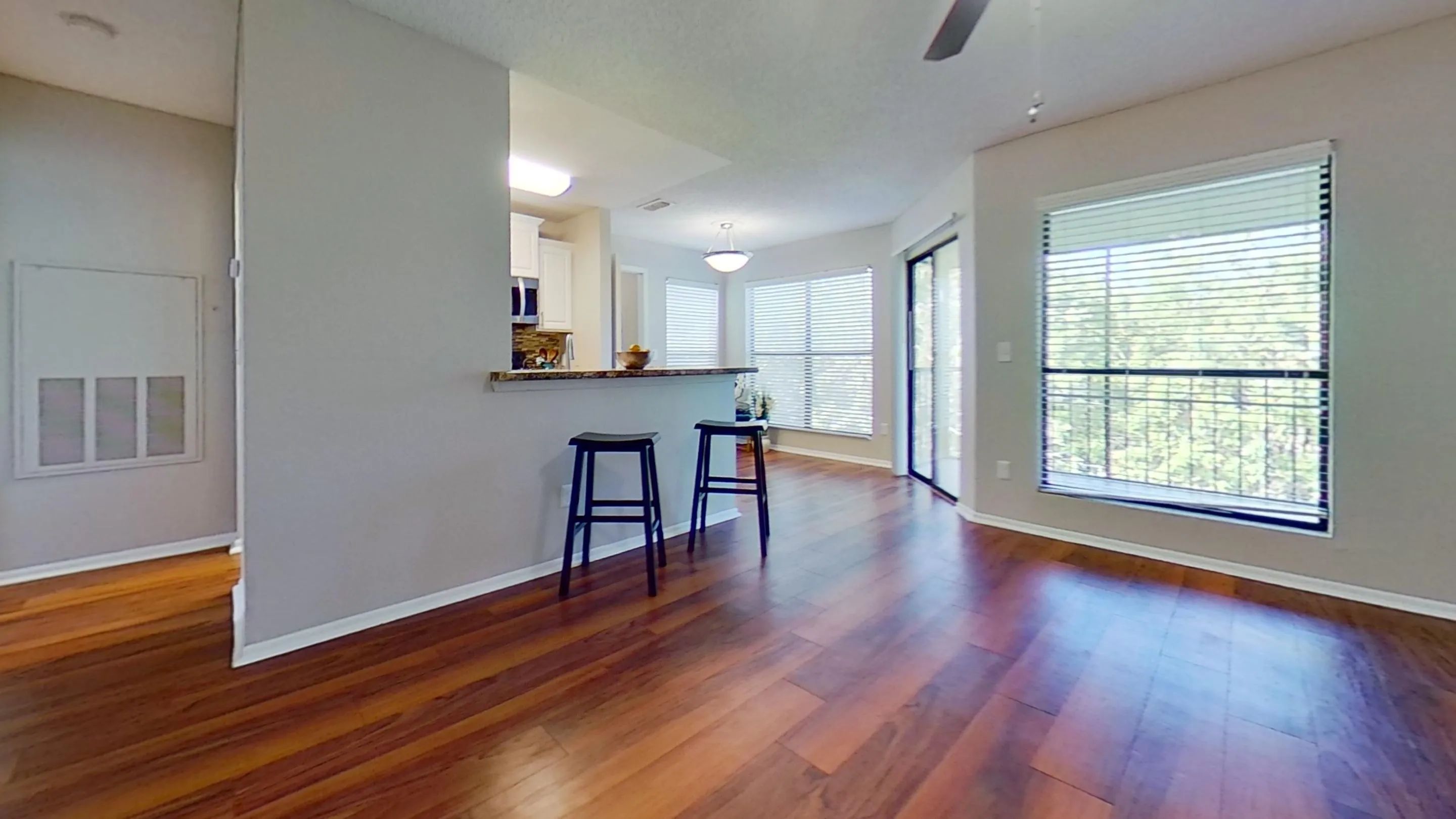 The Martinique Autograph floor plan features a spacious, open-concept living area with warm wood-style flooring, large windows, and a breakfast bar, perfect for entertaining or enjoying quiet moments at home.