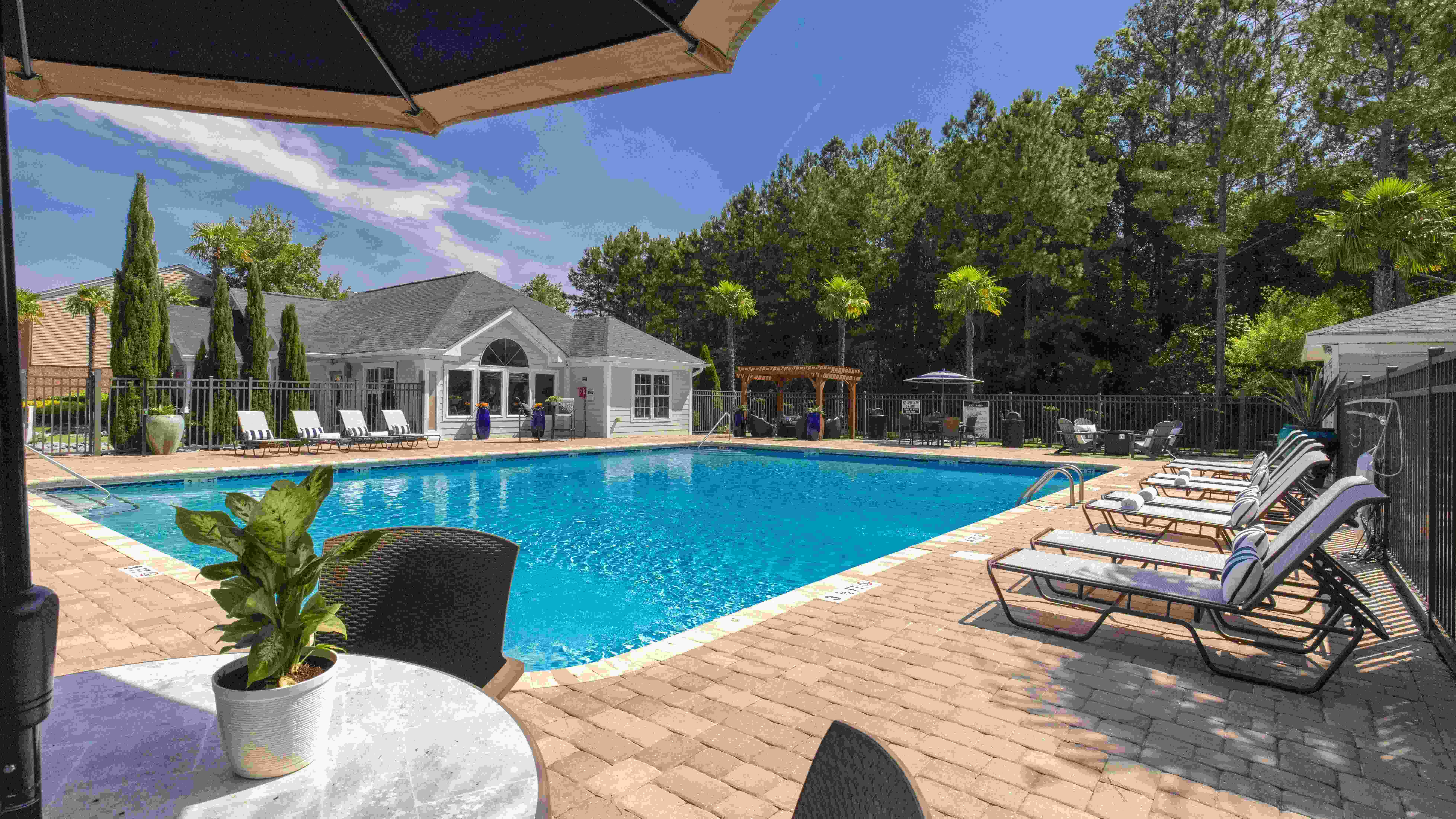 Enjoy delightful poolside seating with tables, umbrellas, and cozy loungers for your comfort around the pool. 