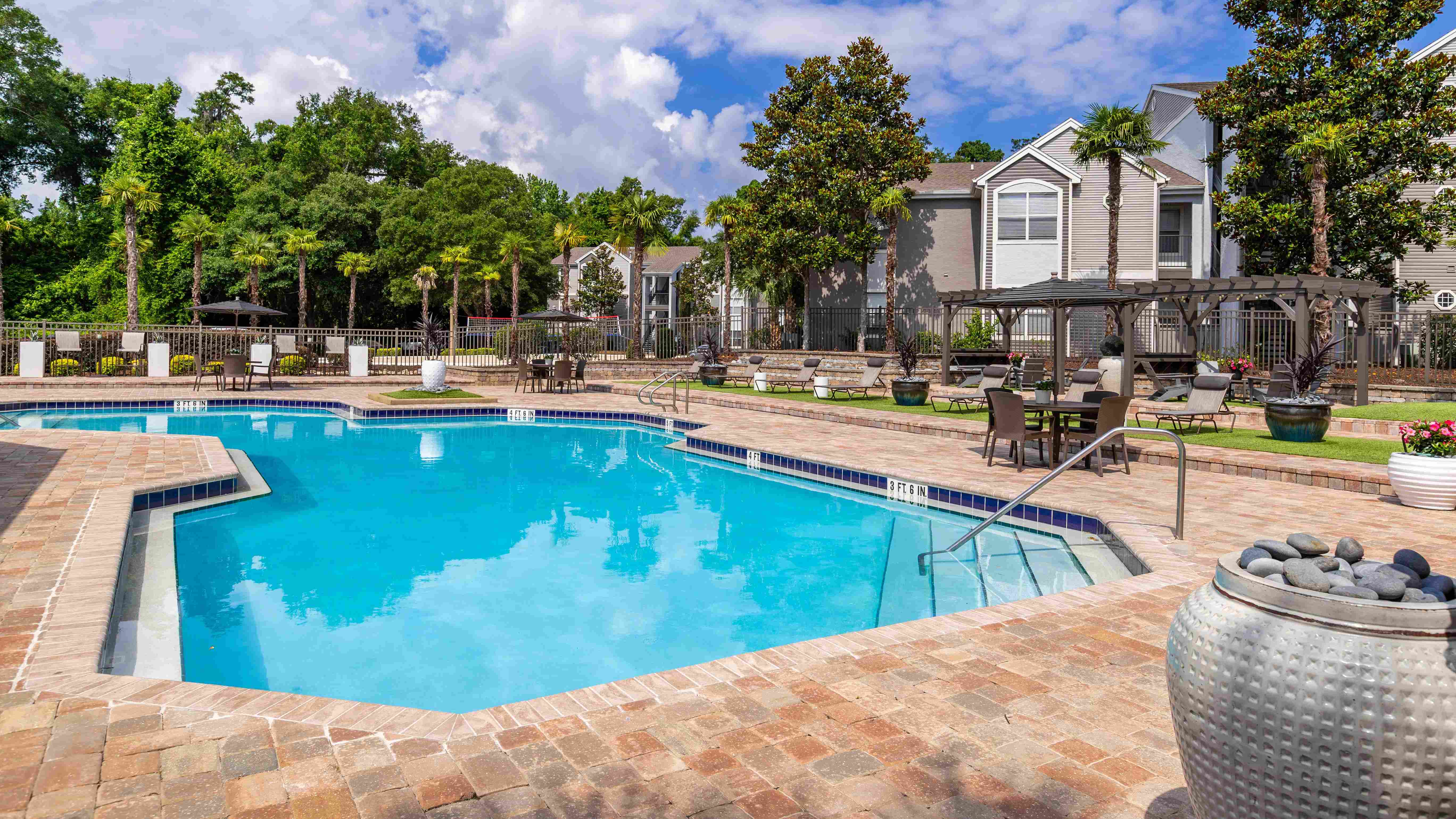 Dive into relaxation with our sparkling swimming pool, complete with shaded pergolas, lounge seating, and lush landscaping that brings the resort vibe home.
