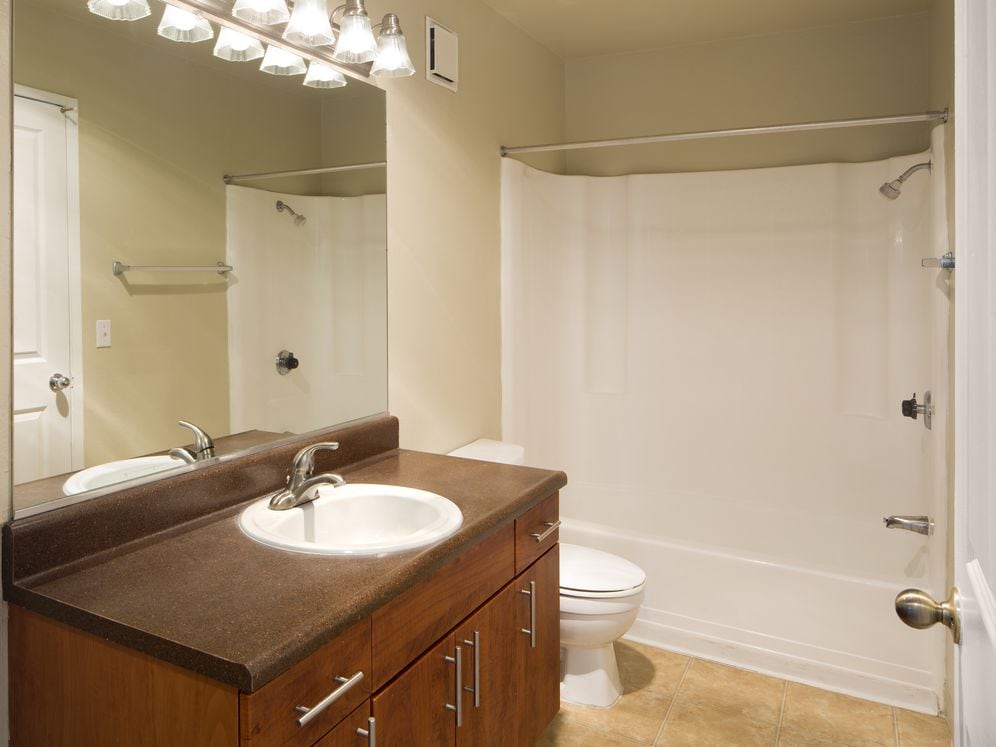 Classic Package II bath with dark laminate countertops, cherry cabinetry, and hard surface flooring