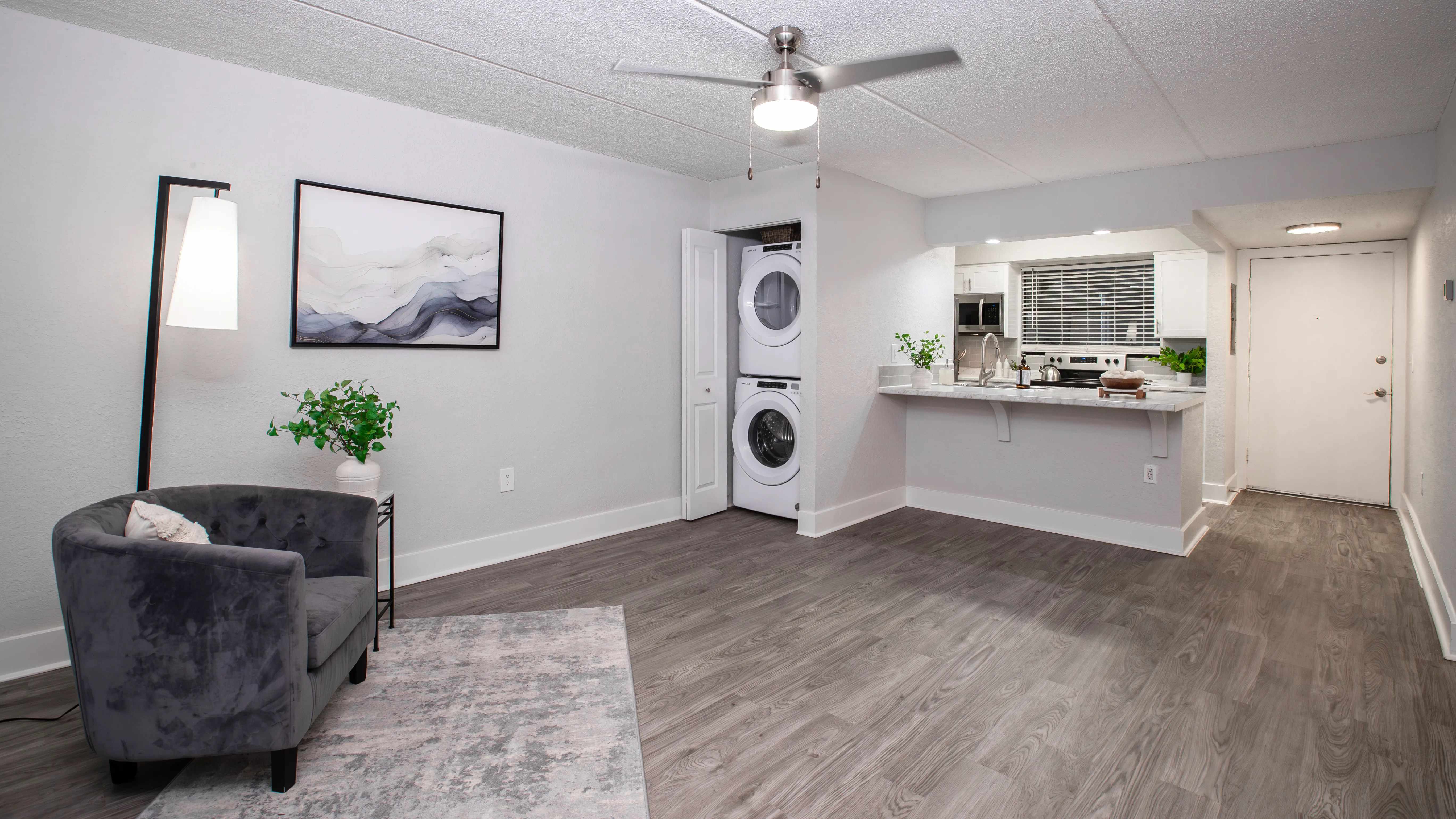 Floor plans feature open-concept living areas featuring stylish wood-style flooring, a ceiling fan, and a convenient in-unit washer and dryer.