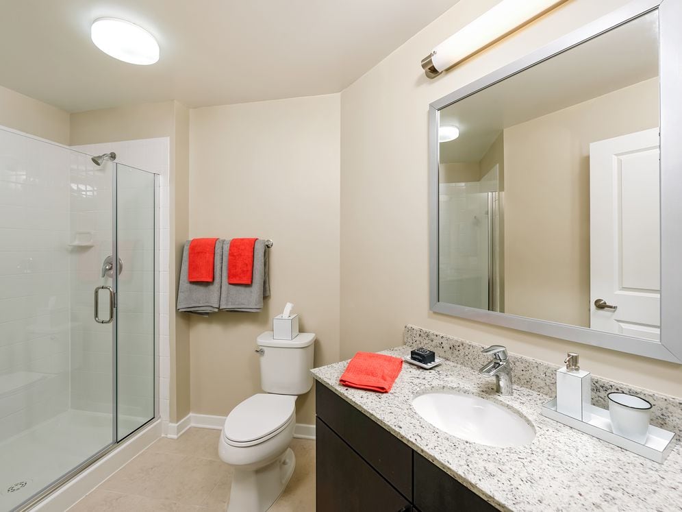 Bathroom with granite countertop, espresso cabinetry and tile flooring