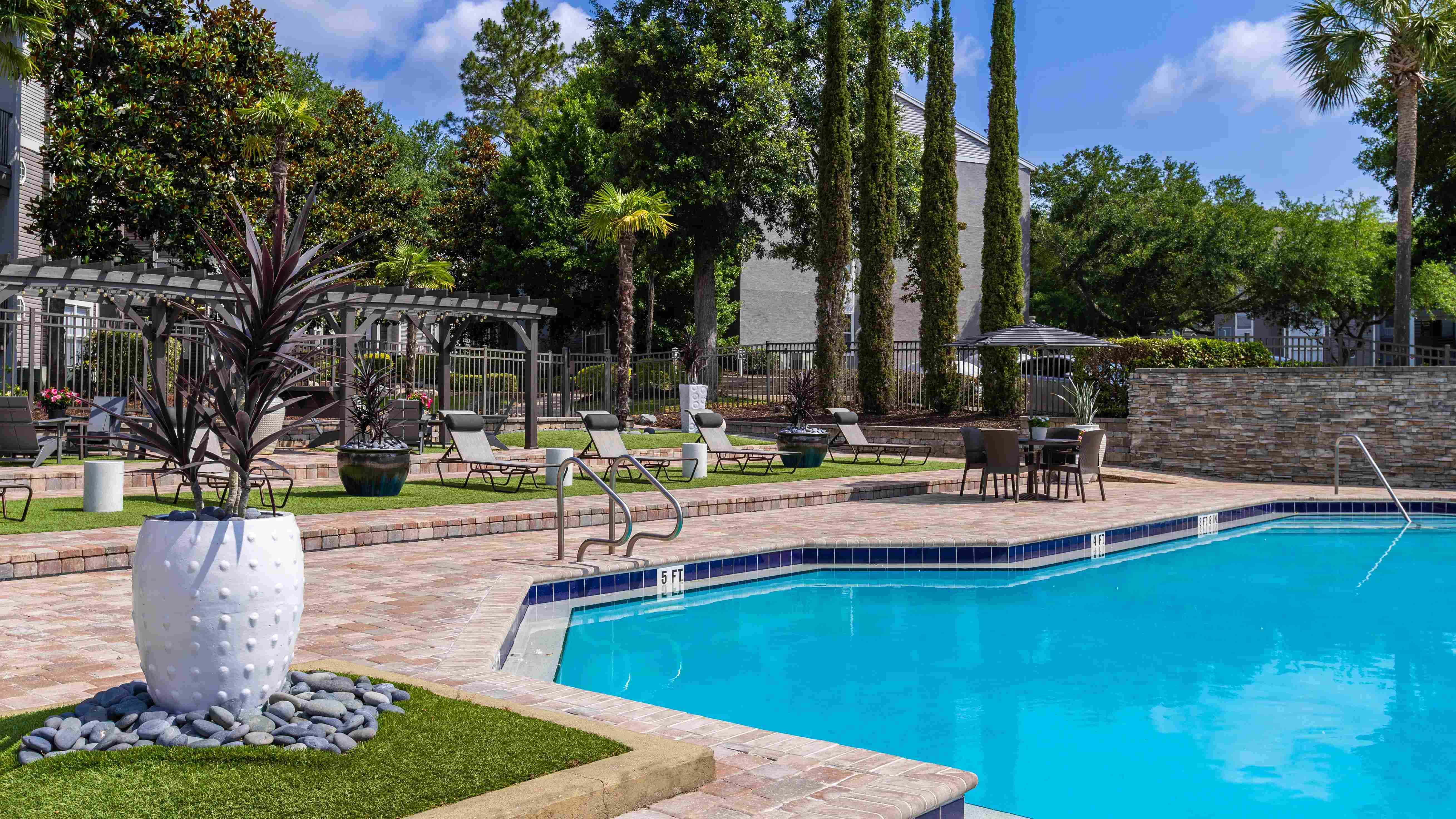 Our expansive pool deck features lounge chairs, shaded seating, and lush landscaping—offering the ideal backdrop for your daily escape.