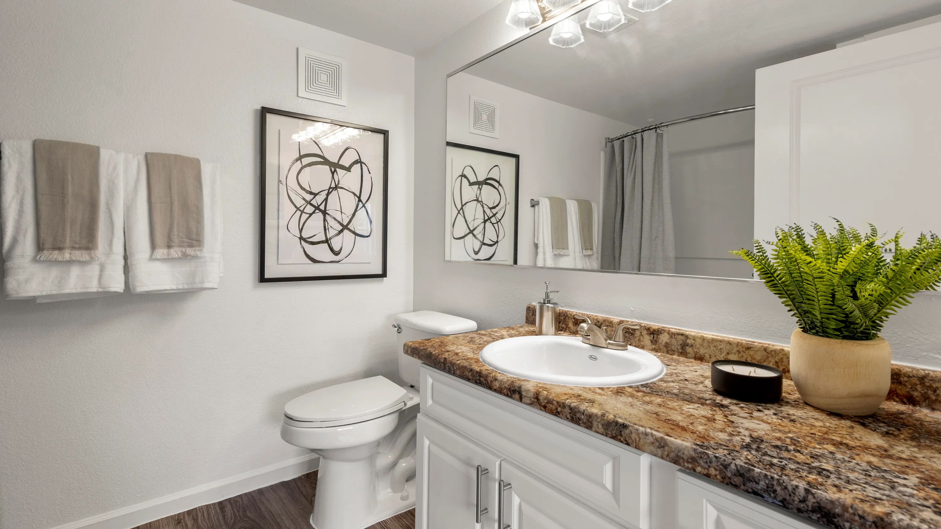 Bathrooms feature sprawling granite-style countertops with ample cabinetry storage below.