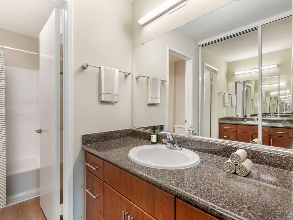 Classic Package II bath with grey speckled granite countertops, chestnut cabinetry, and hard surface flooring