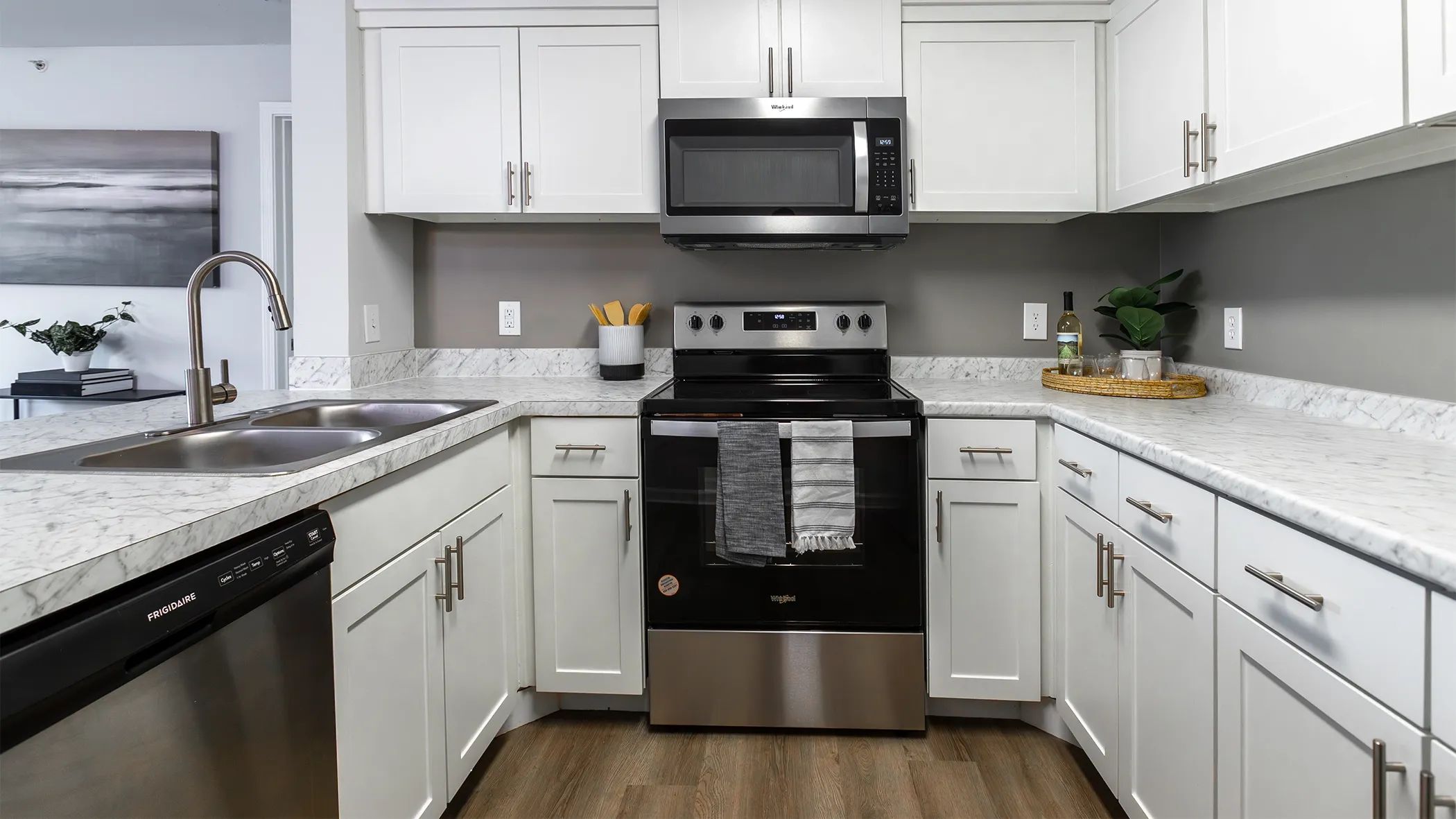 Delight in a culinary escape in our full-equipped kitchens, boasting a sophisticated stainless-steel appliance package including the coveted dishwasher and a mounted microwave over the stove.