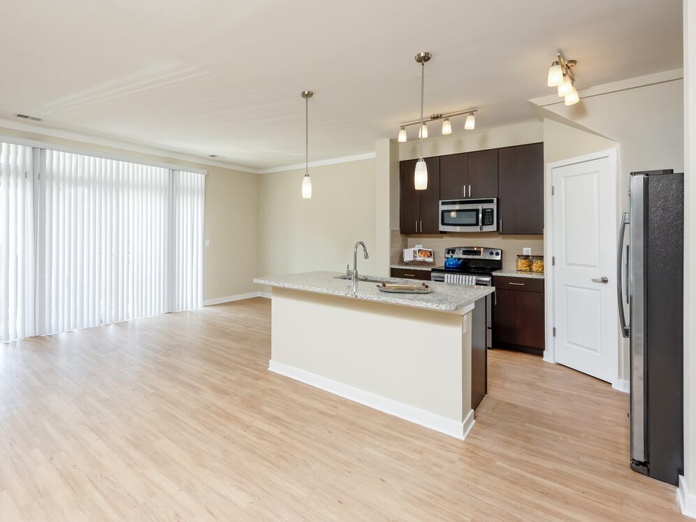 Classic Package II townhome kitchen and living room with hard surface flooring (select homes)