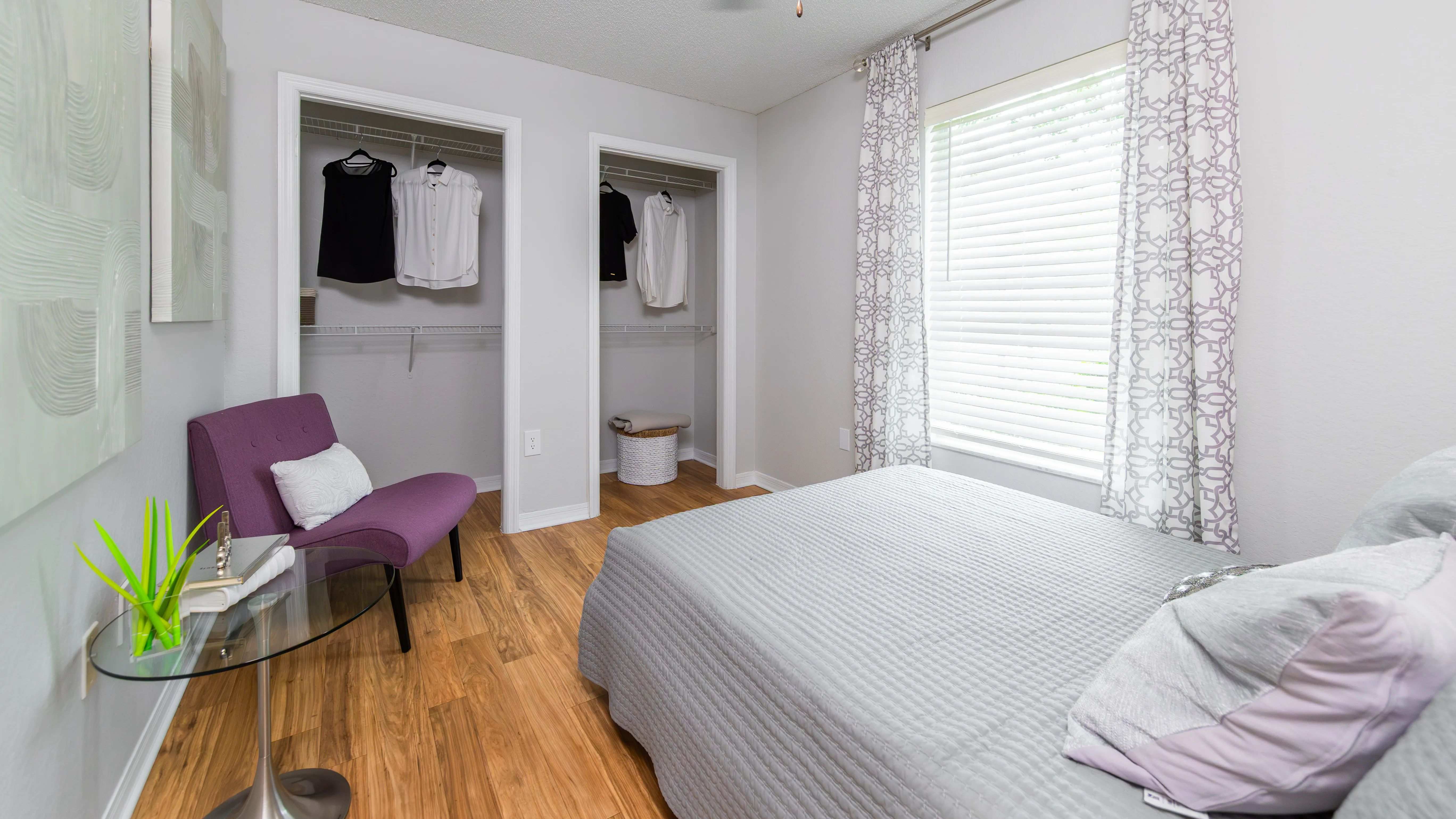 This cozy second bedroom is perfect for guests, a home office, or a stylish retreat—complete with dual closets and modern wood-style flooring.